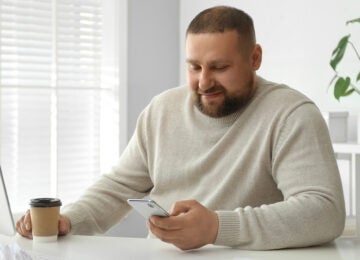 Obese man on phone at desk