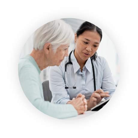 Doctor talking to older patient and showing information on tablet