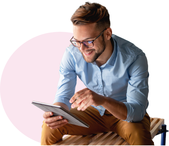 Young man sitting and smiling at tablet